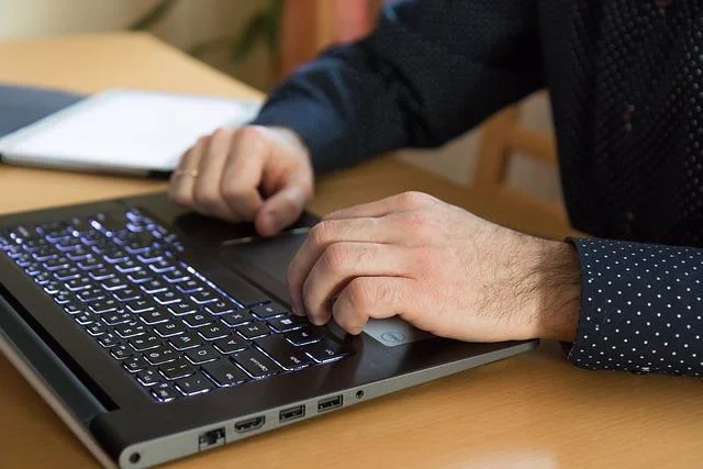 Person using a laptop, highlighting remote auditing and certification processes related to ISO standards.