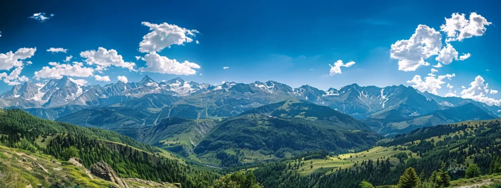 ein strahlend blauer himmel über einer majestätischen berglandschaft, wo die schroffen gipfel mit schimmerndem schnee bedeckt sind und sich leuchtend grüne wälder am fuße der berge erstrecken.