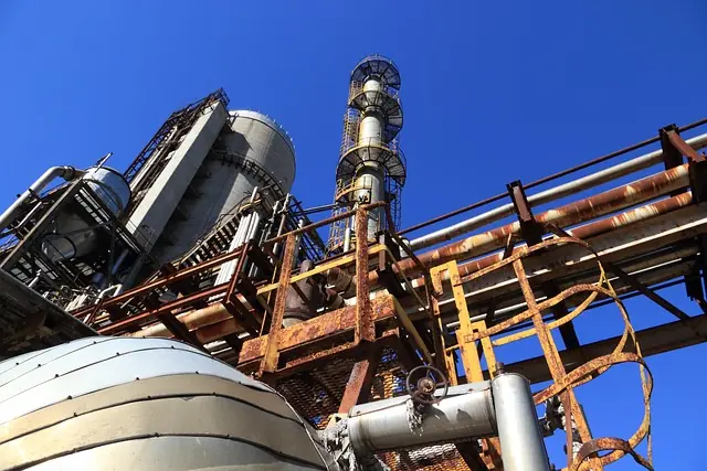 Industrieanlage in der Chemie- und Pharmaindustrie mit sichtbaren Rohren und Turmstrukturen unter blauem Himmel, symbolisiert Energieeffizienz und Sicherheitsmanagement in der Branche.