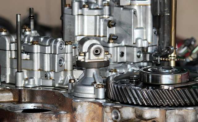 Detailaufnahme eines Automobilmotors mit verschiedenen mechanischen Komponenten, die für die Effizienz und Sicherheit in der Automobilindustrie wichtig sind, im Kontext von ISO-Zertifizierungen und Arbeitssicherheit.